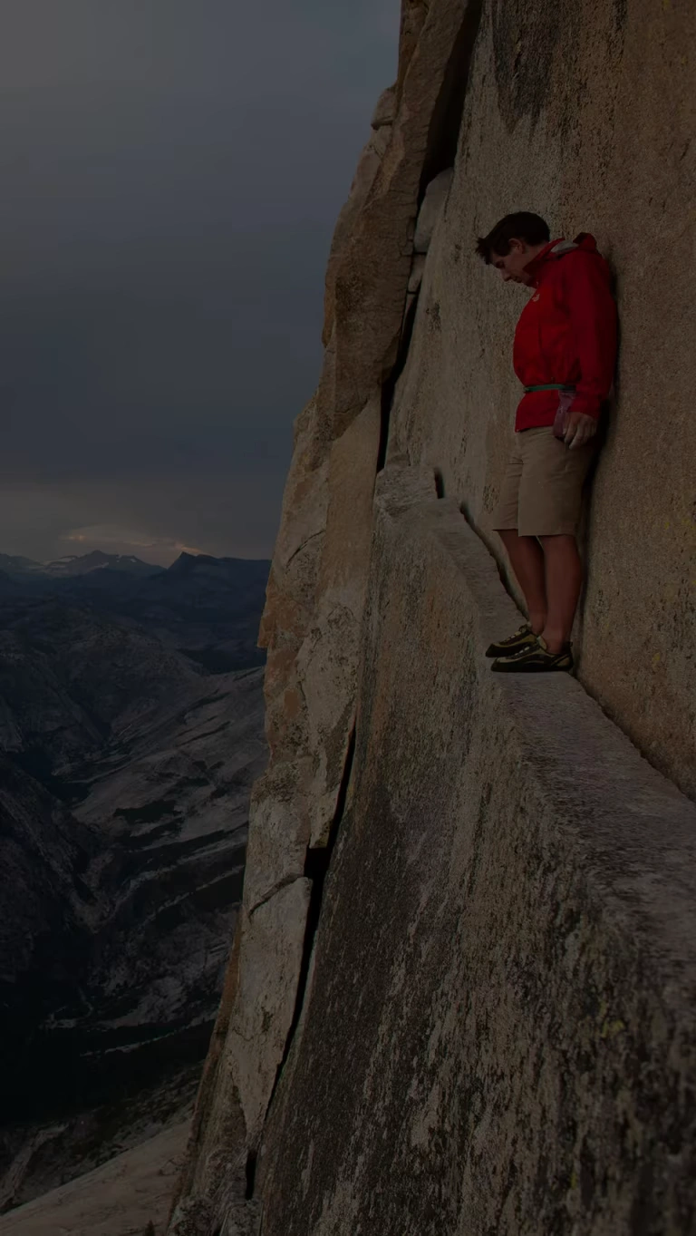 Climber, Alex Honnold, looks down on the Yosemite Valley from an exposed ledge.
