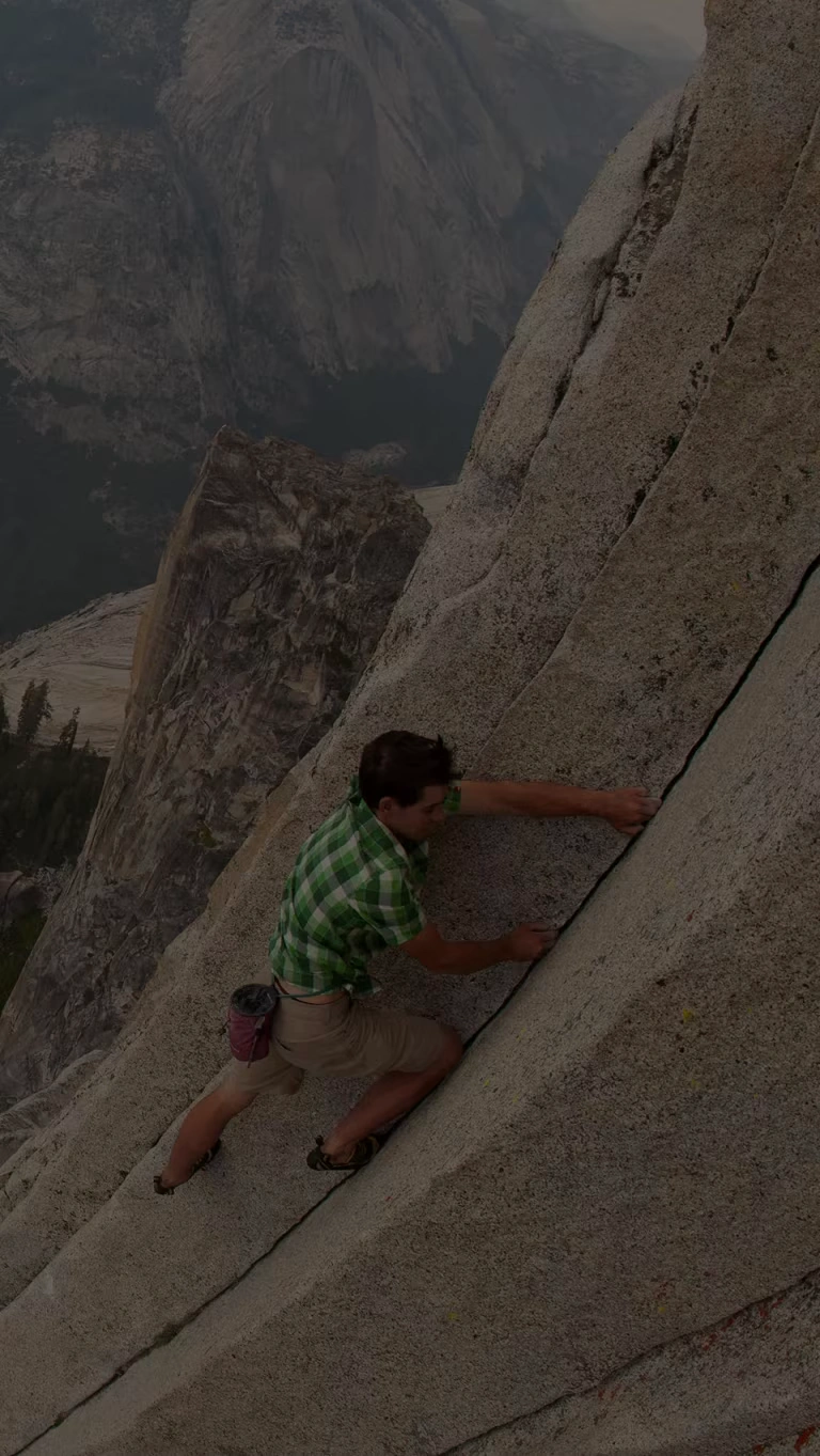 Climber, Alex Honnold, grips the granite wall on his free solo ascent of Half Dome in Yosemite National Park.