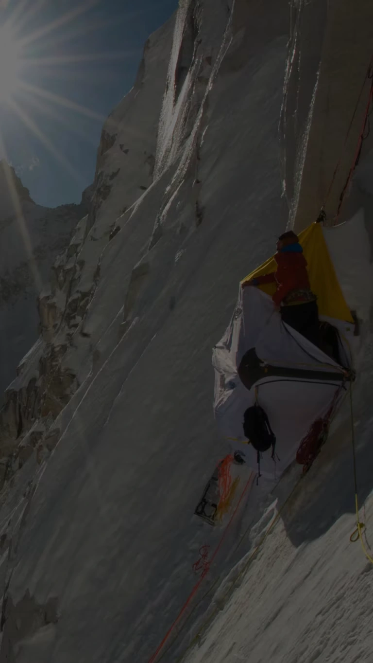 A mountaineer looks out across the surrounding summits.