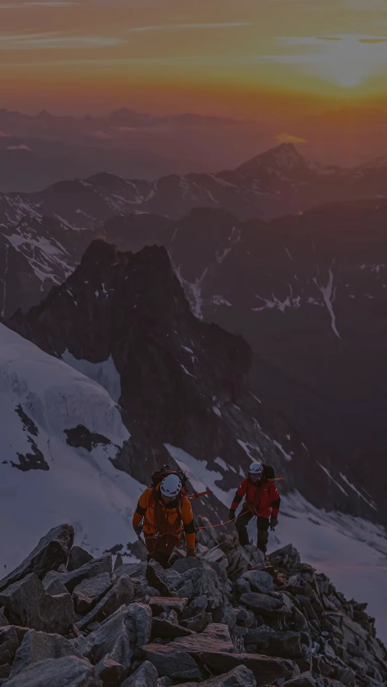 At sunrise, a pair of mountaineers make the final push towards the summit.